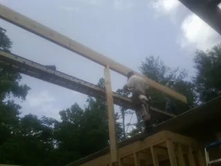 Carpenter setting a ridge beam over a new addition frame — Ice Dam Removal by Roofing Brothers in Sheridan