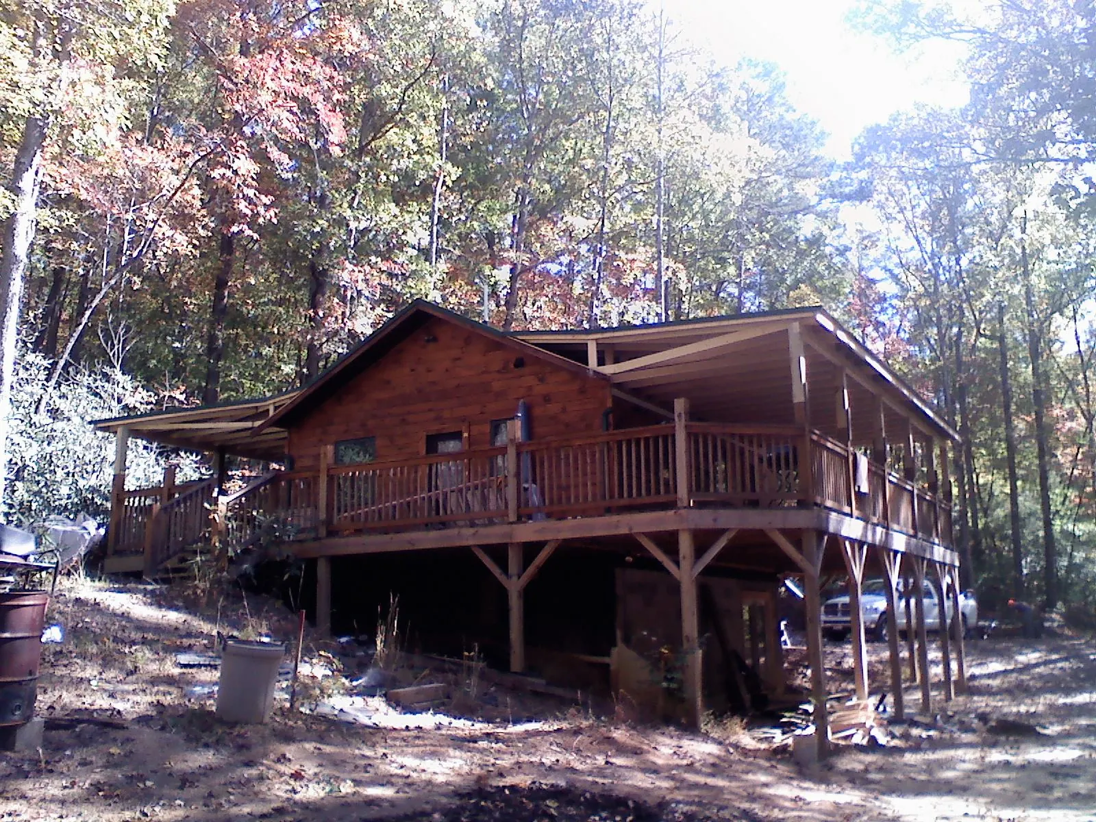 Log cabin with a wraparound porch and metal roof in the fall in Sheridan